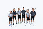 Group of junior golfers in black and white Escape Artist polos and black shorts holding clubs