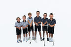 Group of junior golfers in black and white Escape Artist polos and black shorts holding clubs
