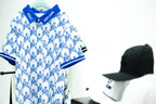White and blue Escape Artist polo on a hanger, with caps