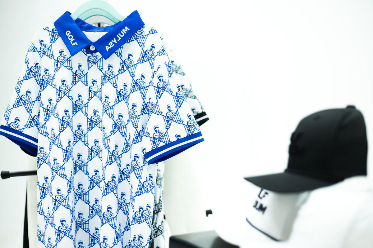 White and blue Escape Artist polo on a hanger, with caps