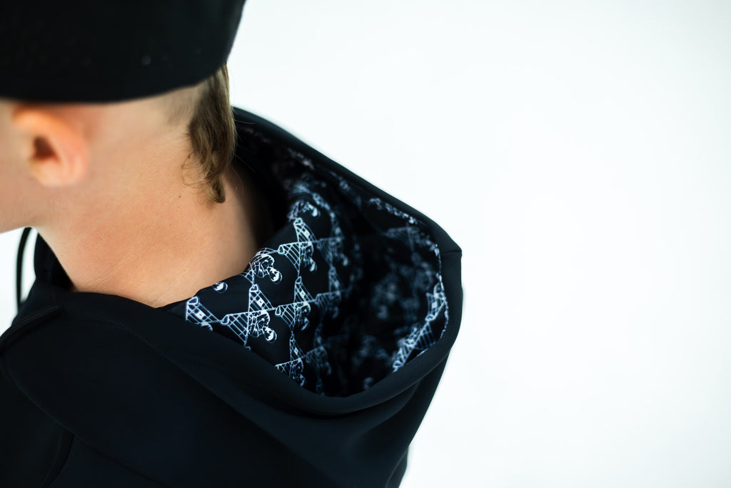 Patterned lining inside the black hoodie's hood, from behind