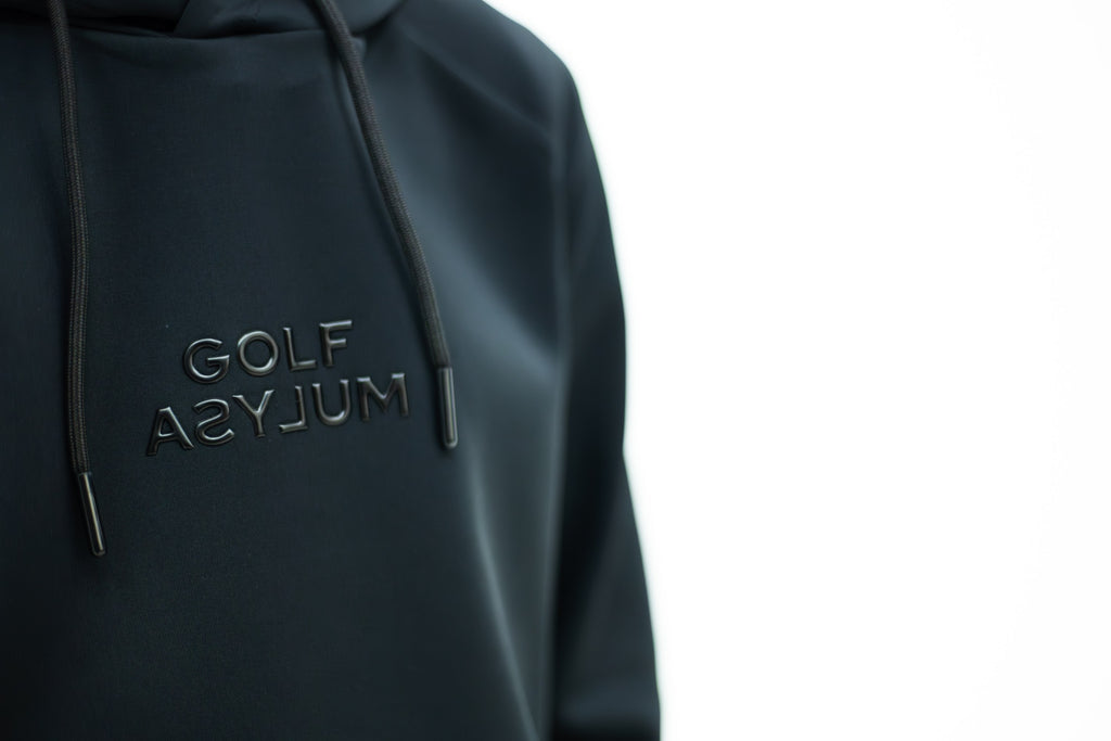 Embossed Golf Asylum logo on the black hoodie, close up