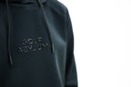 Embossed Golf Asylum logo on the black hoodie, close up